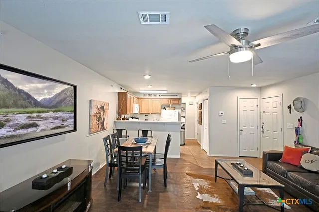 a view of a dining room with furniture a chandelier and wooden floor