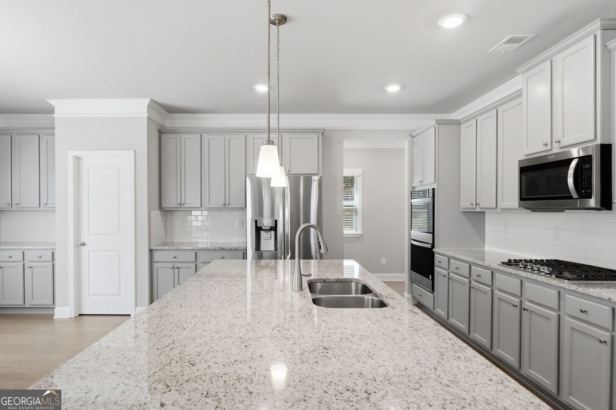 604 O'Brians Path McDonough, GA 30253 - Photo 12 of 41 a kitchen with stainless steel appliances kitchen island granite countertop a refrigerator a stove a sink and white cabinets with wooden floor