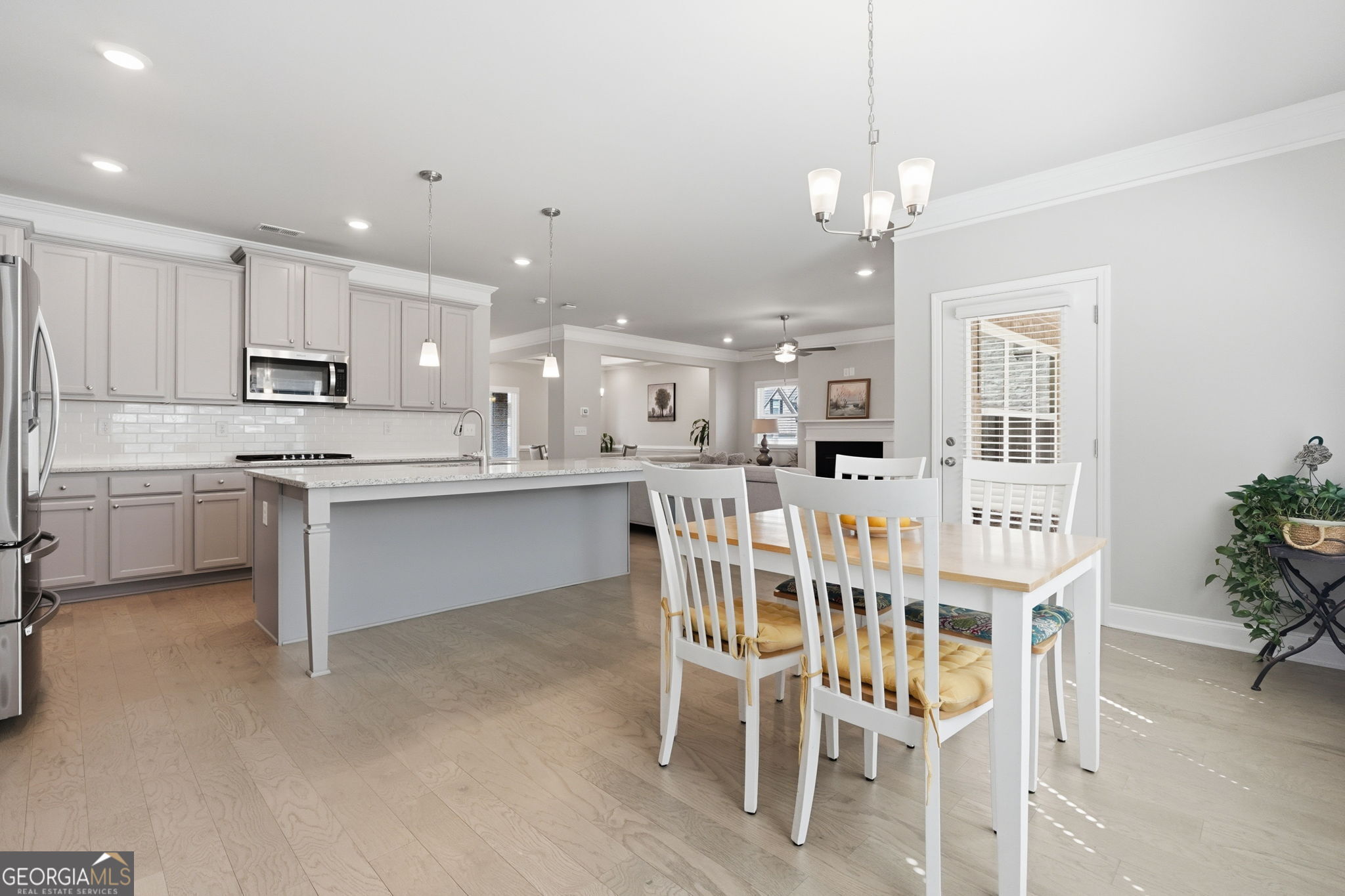 604 O'Brians Path McDonough, GA 30253 - Photo 13 of 41 a kitchen with stainless steel appliances kitchen island granite countertop a dining table chairs and white cabinets