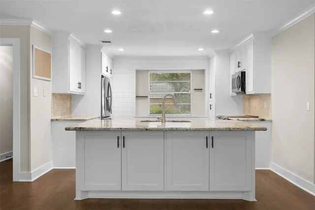 a kitchen with granite countertop a sink a stove and microwave