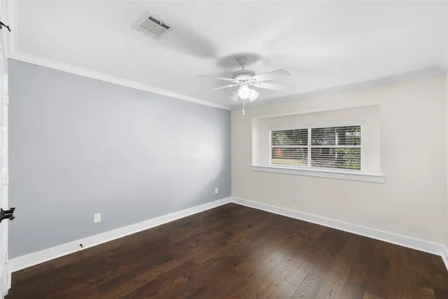 an empty room with wooden floor and window