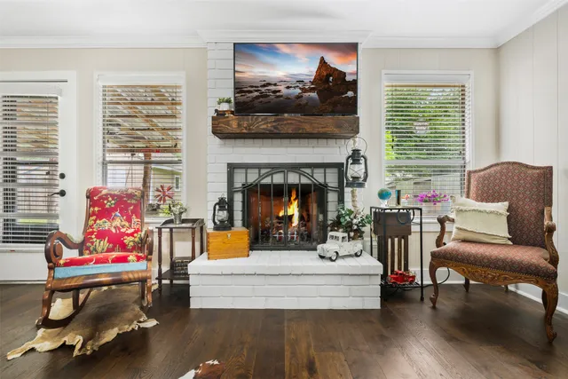 a living room with furniture a fireplace and a large window