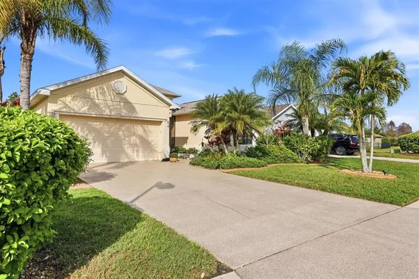 a view of a house with a yard and palm trees