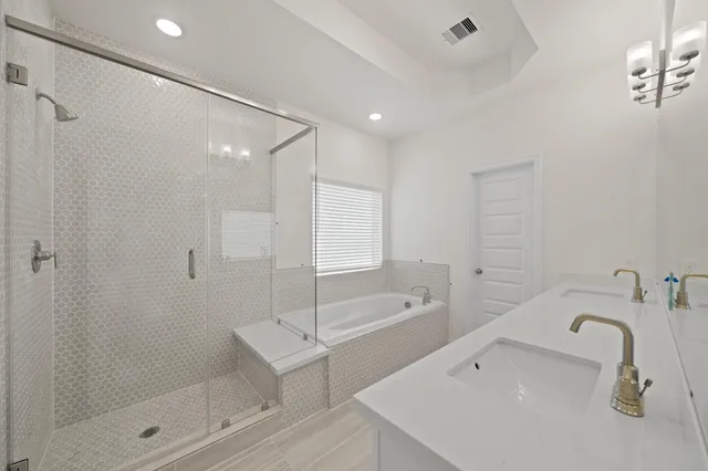 a bathroom with a tub sink shower and mirror