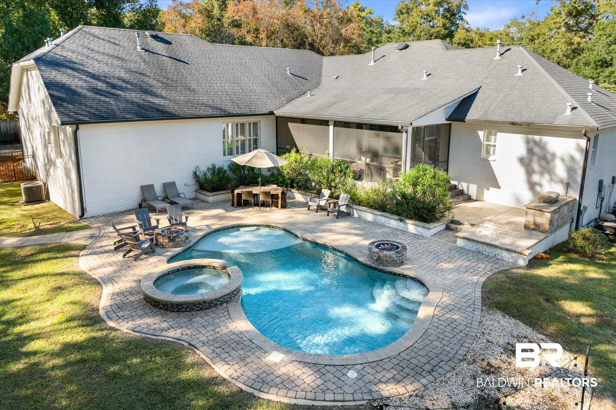 3713 Old Shell Road Mobile, AL 36608 - Photo 39 of 52 View of swimming pool featuring an in ground hot tub, an outdoor fire pit, a patio, an outdoor bar, and a lawn