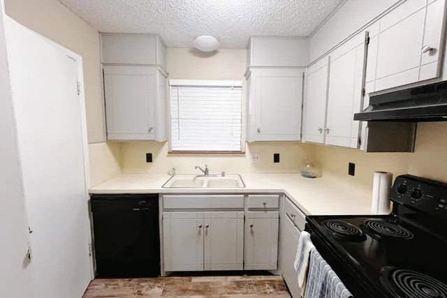 a kitchen with a sink stove and cabinets