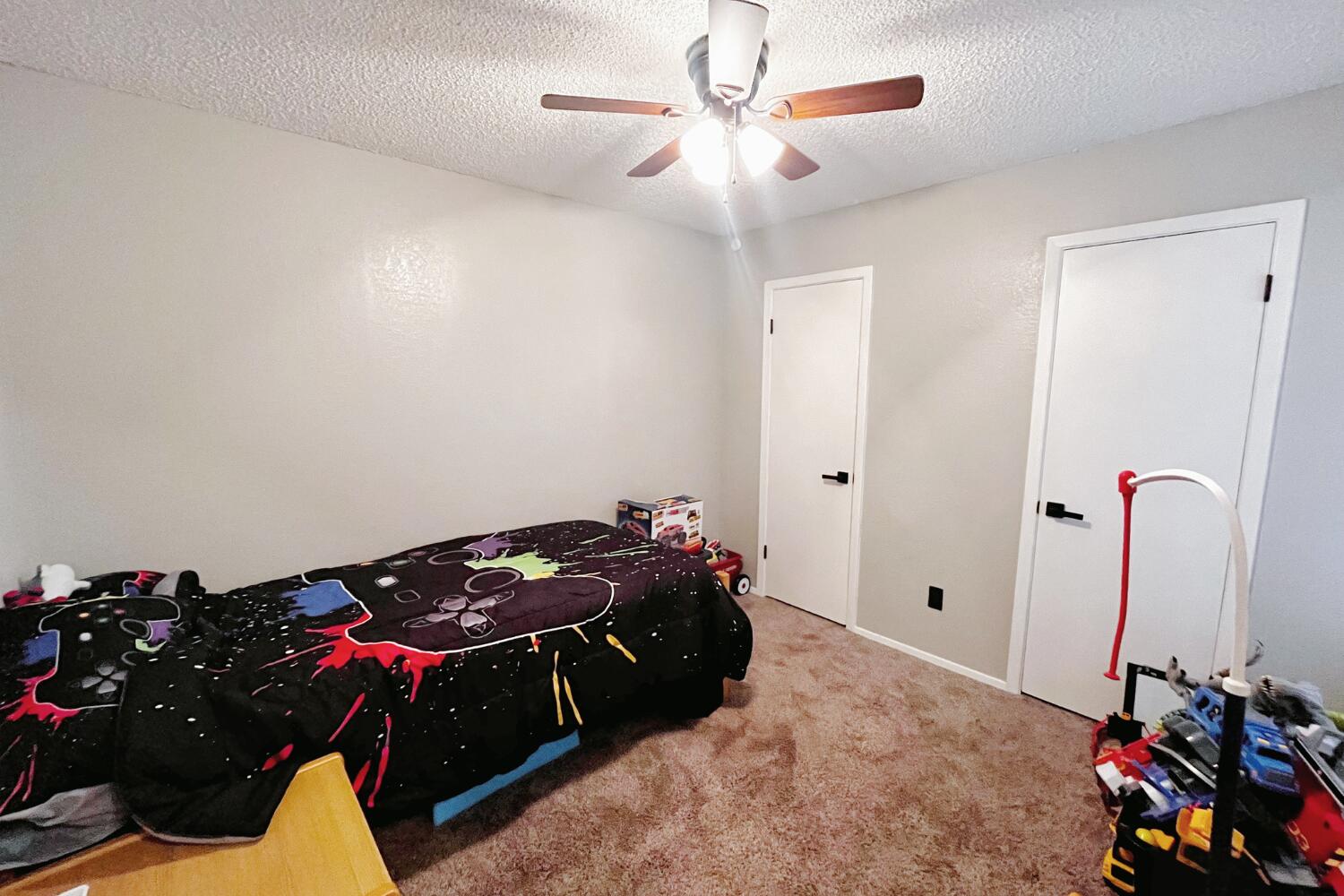 5806 7th Street Lubbock, TX 79416 - Photo 20 of 26 a bedroom with a bed and a chandelier