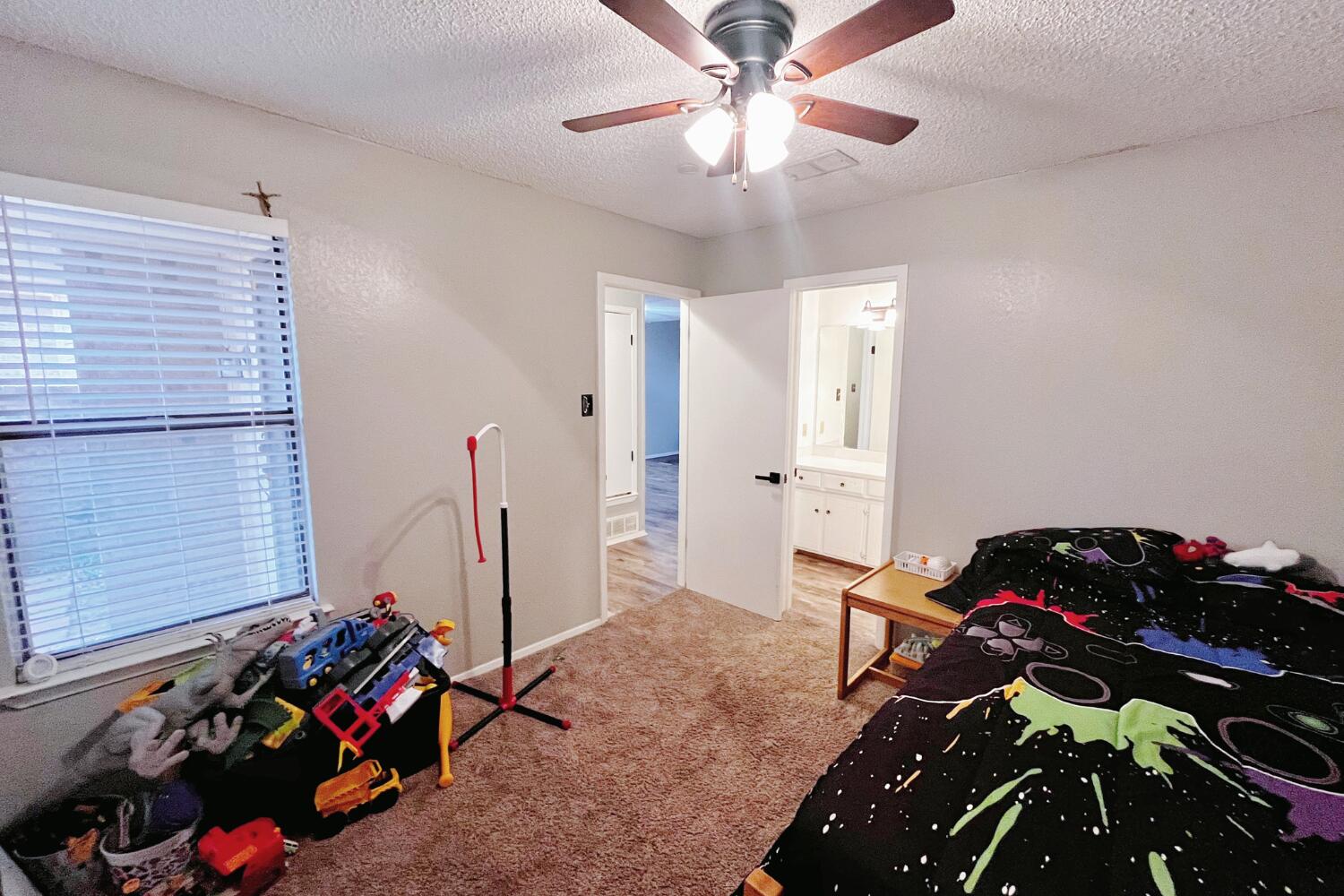 5806 7th Street Lubbock, TX 79416 - Photo 21 of 26 a bedroom with a bed and a chandelier