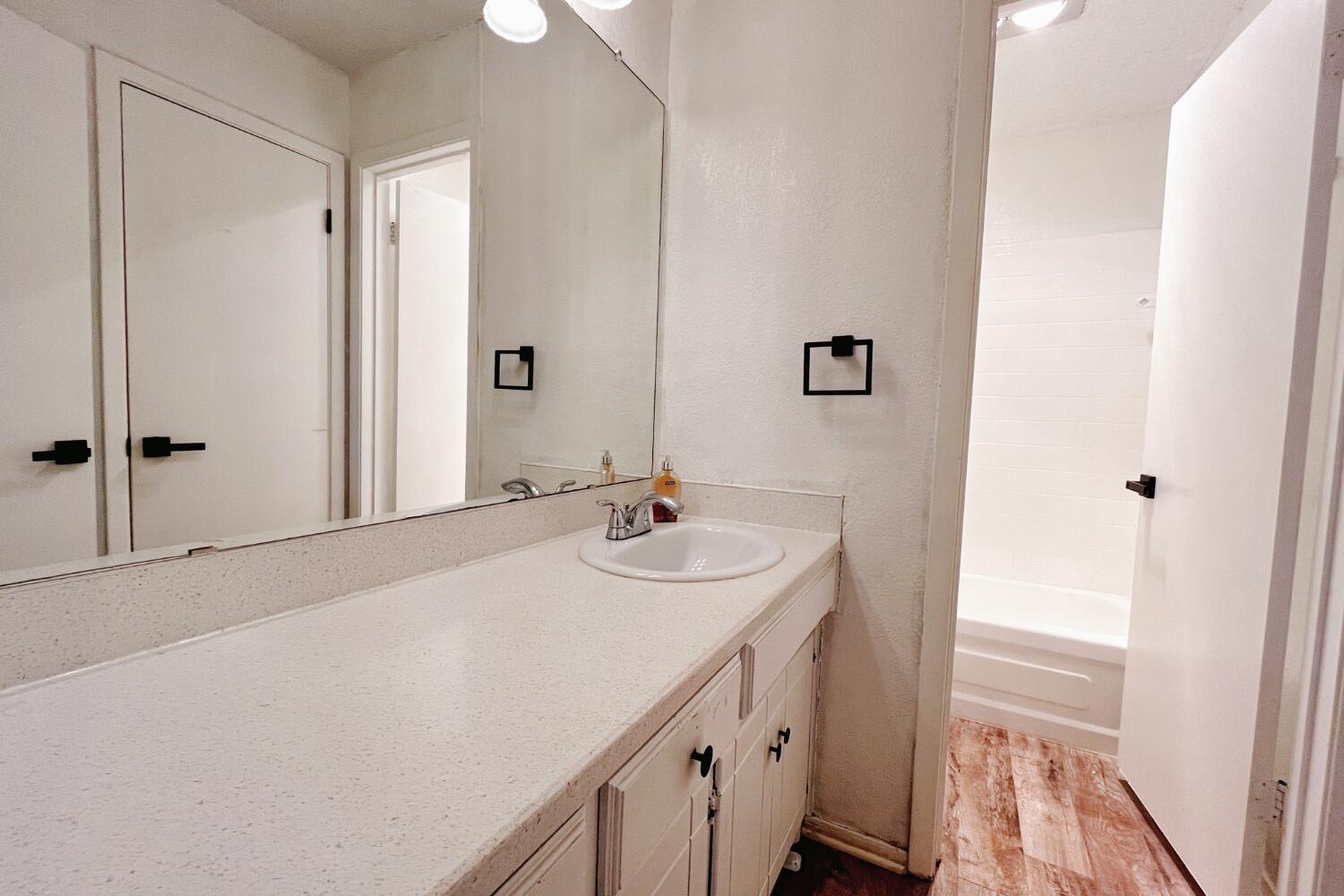 5806 7th Street Lubbock, TX 79416 - Photo 23 of 26 a bathroom with a sink a mirror and a shower