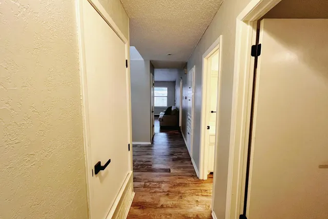 a view of a hallway with wooden floor and staircase