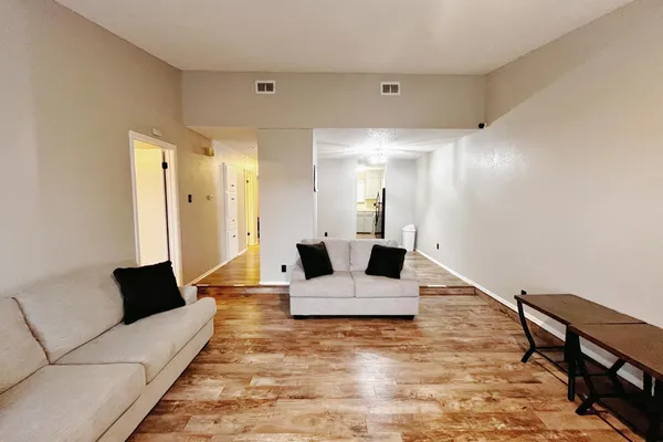 a living room with furniture and wooden floor