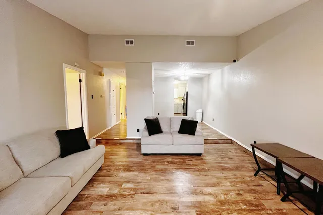 a living room with furniture and wooden floor