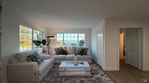 a living room with furniture a table and a large window