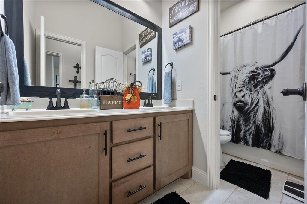 4021 Grove Valley Road Midlothian, TX 76065 - Photo 25 of 27 Bathroom featuring double vanity, light tile patterned flooring, and a shower with curtain