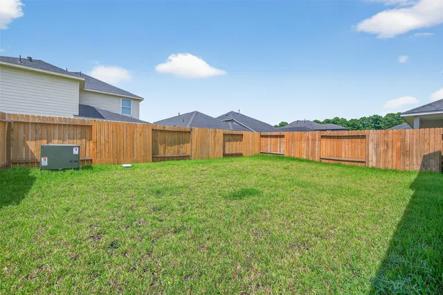 a view of a backyard with table and chairs and wooden fence