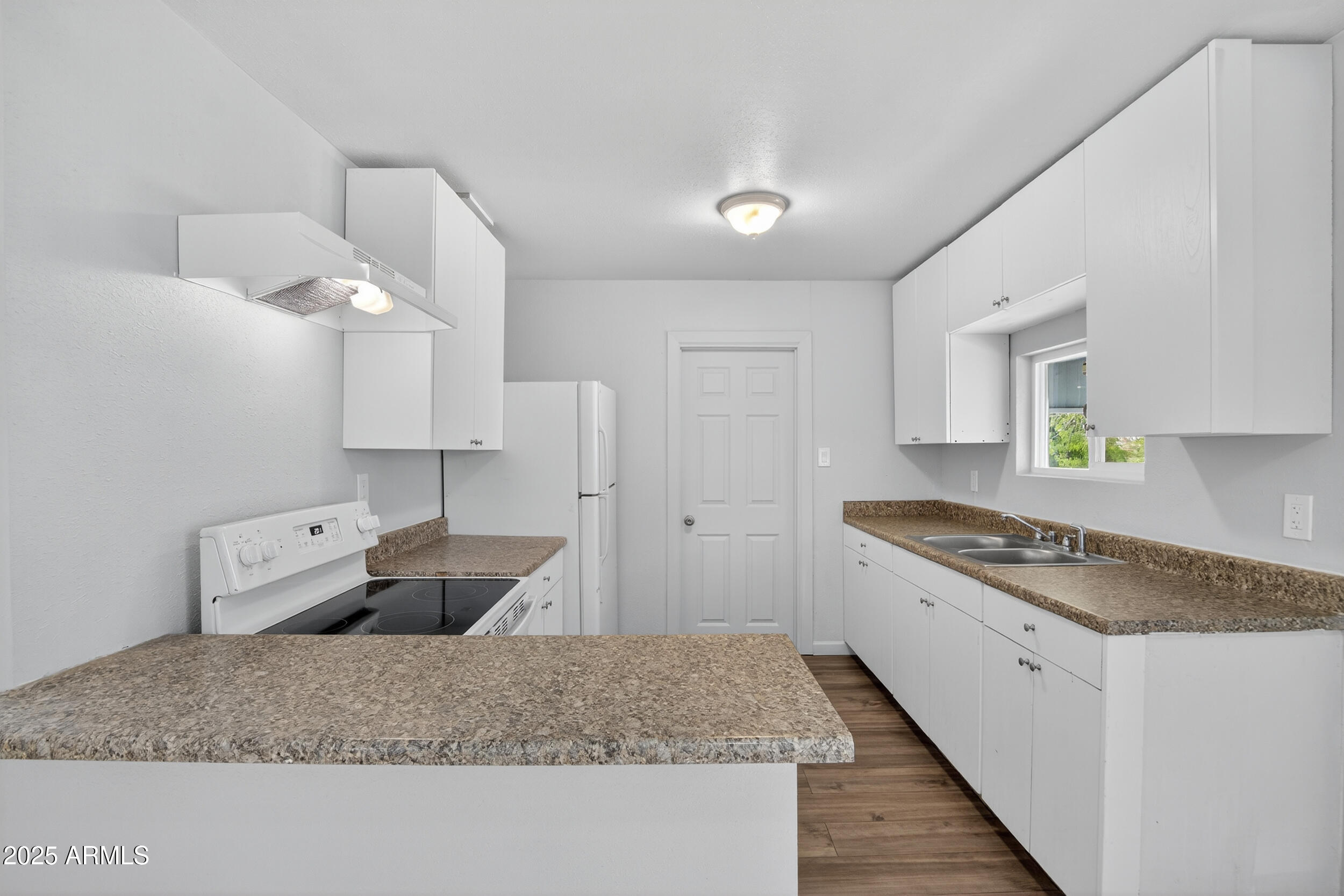 a kitchen with granite countertop a sink stove and cabinets