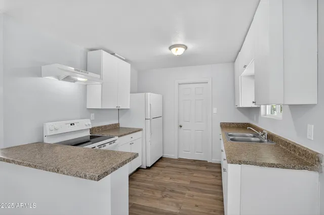 a kitchen with granite countertop a sink and a stove top oven