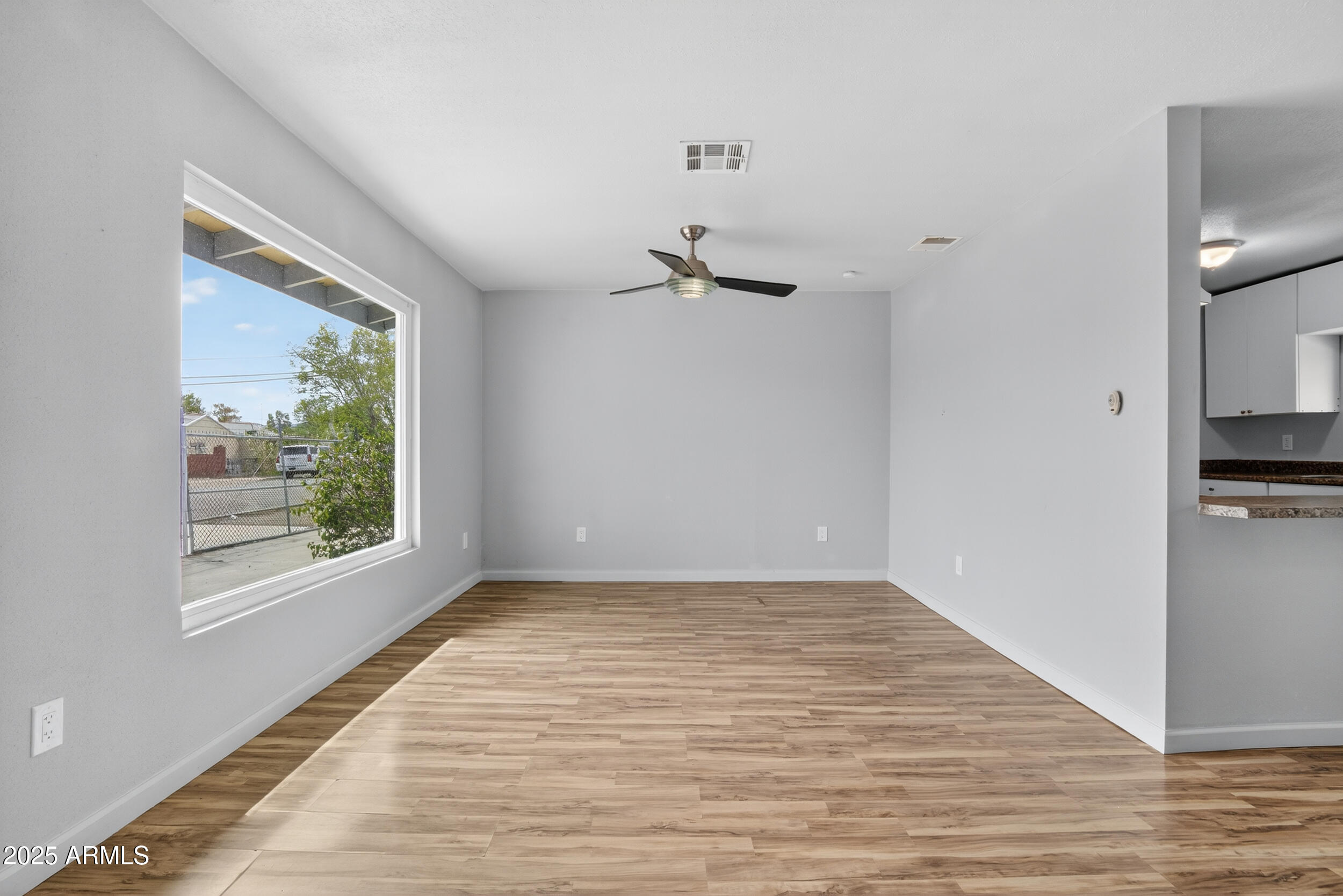 1410 South 24th Avenue, Unit A Phoenix, AZ 85009 - Photo 15 of 36 a view of empty room with window and wooden floor