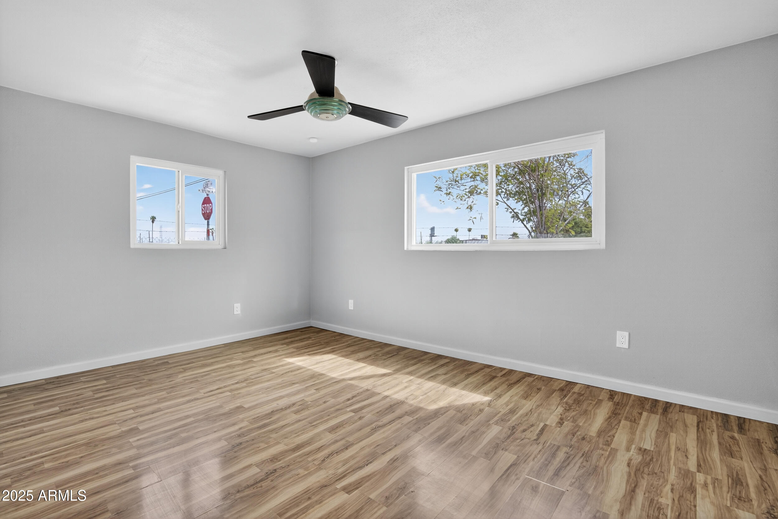 1410 South 24th Avenue, Unit A Phoenix, AZ 85009 - Photo 17 of 36 a view of an empty room with wooden floor and a window