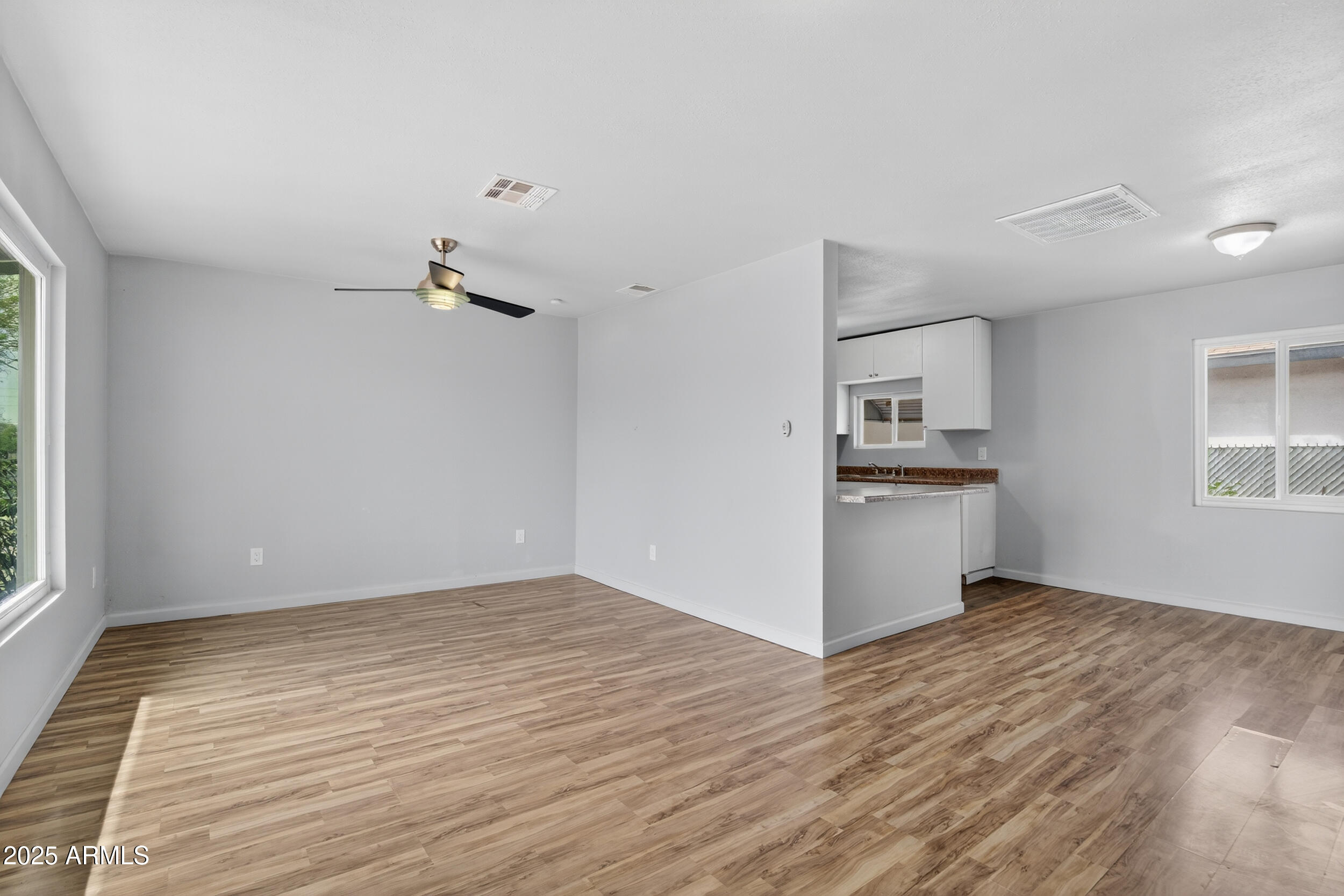 1410 South 24th Avenue, Unit A Phoenix, AZ 85009 - Photo 18 of 36 a view of empty room with wooden floor and window