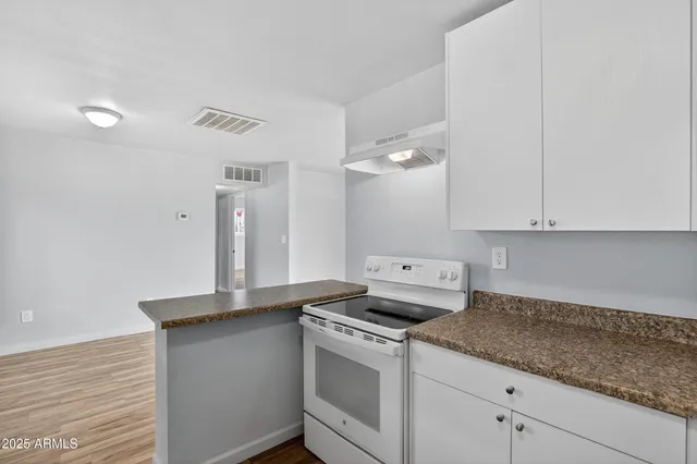 a kitchen with granite countertop white cabinets and white appliances