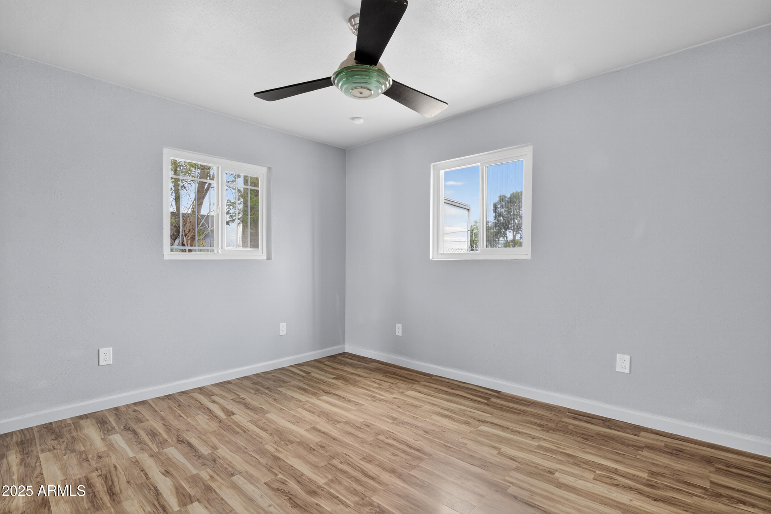 1410 South 24th Avenue, Unit A Phoenix, AZ 85009 - Photo 23 of 36 a view of empty room with wooden floor and fan