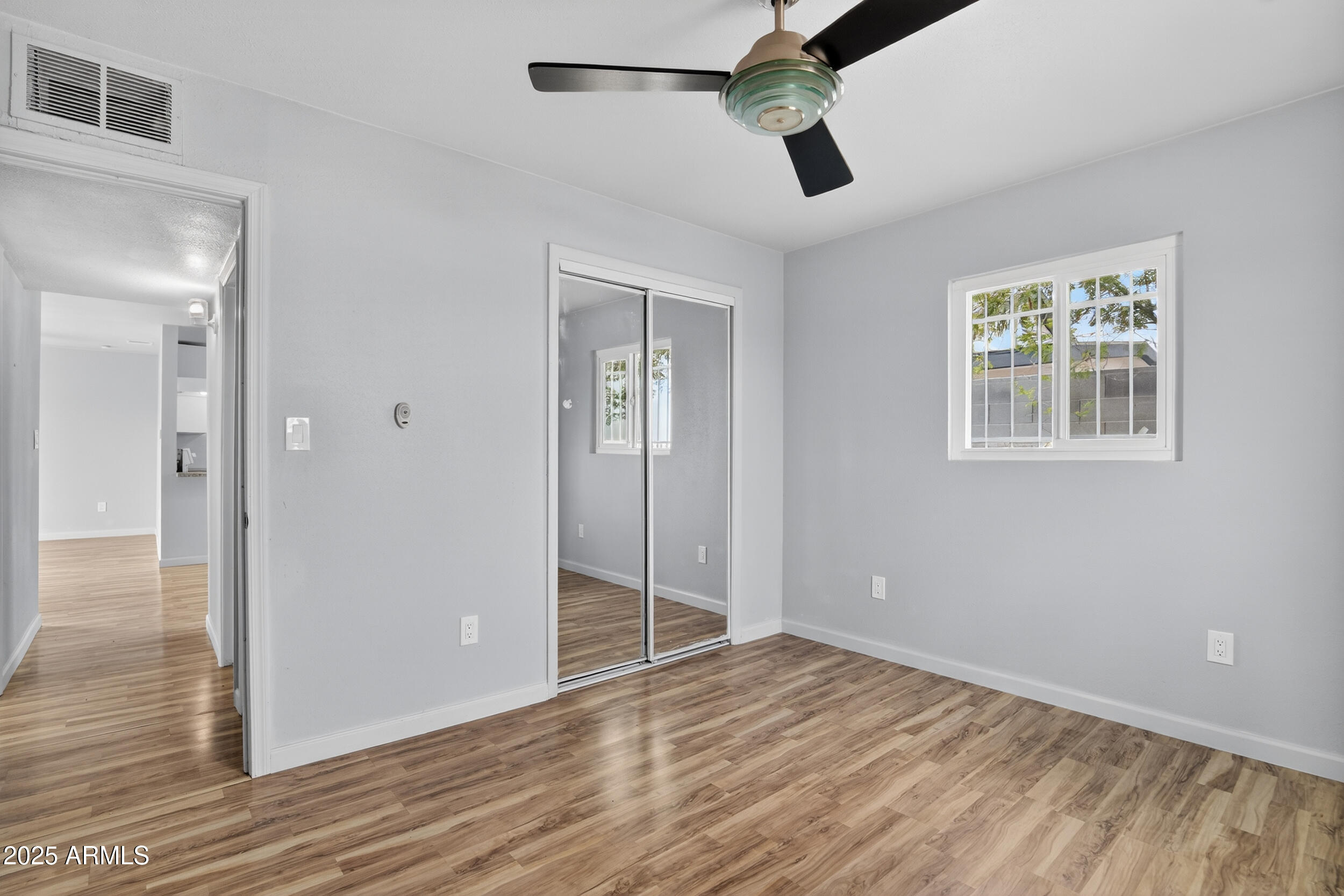 1410 South 24th Avenue, Unit A Phoenix, AZ 85009 - Photo 25 of 36 a view of an empty room with wooden floor and a window