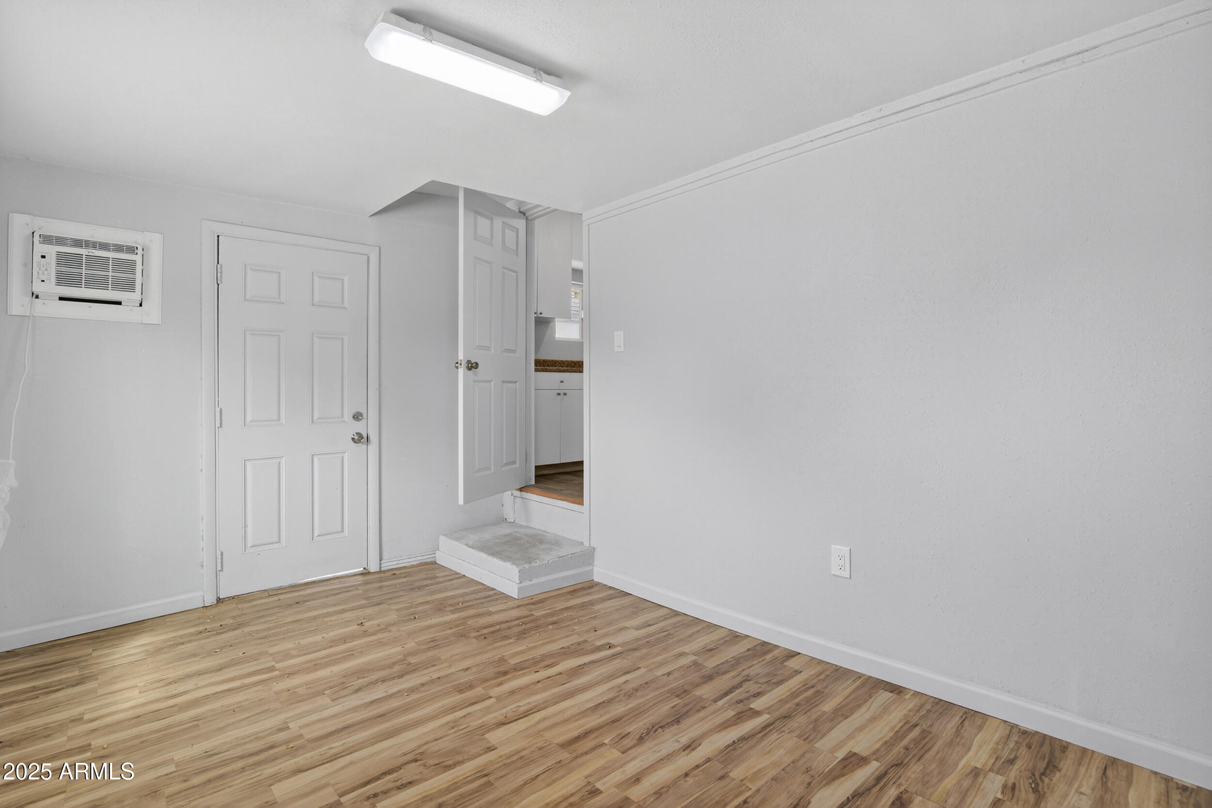 1410 South 24th Avenue, Unit A Phoenix, AZ 85009 - Photo 28 of 36 a view of a room with wooden floor and a ceiling fan