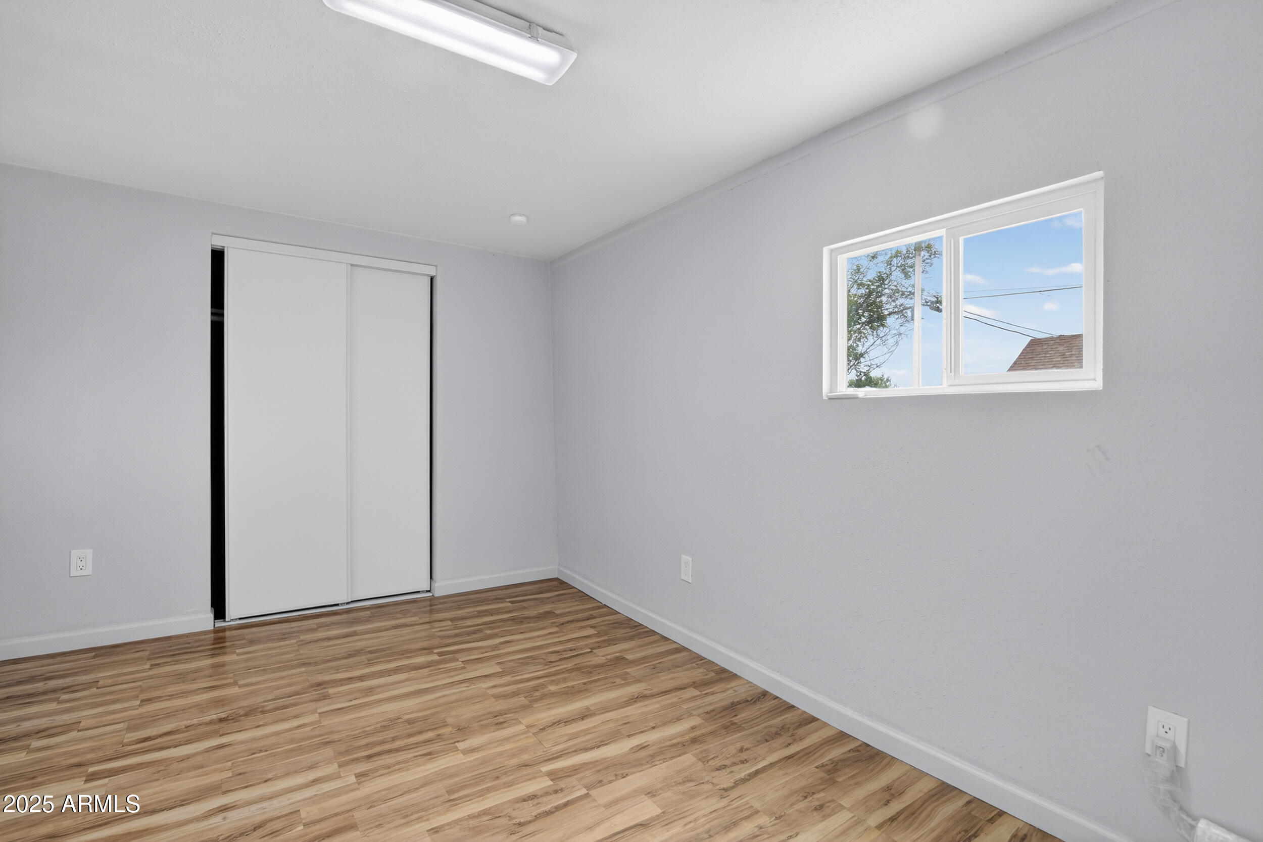 1410 South 24th Avenue, Unit A Phoenix, AZ 85009 - Photo 30 of 36 a view of an empty room with wooden floor