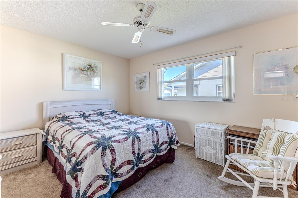 6163 Spyglass Court Spring Hill, FL 34606 - Photo 38 of 73 a bedroom with a bed and a chair