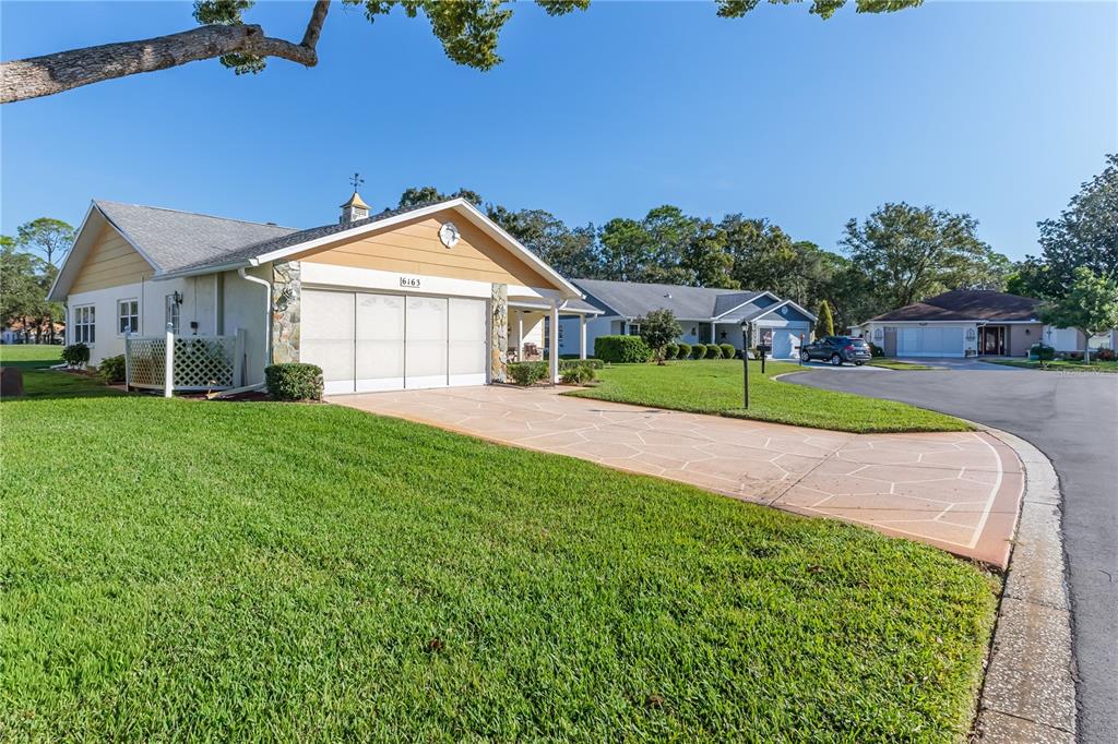 6163 Spyglass Court Spring Hill, FL 34606 - Photo 59 of 73 a view of a house next to a big yard and large trees