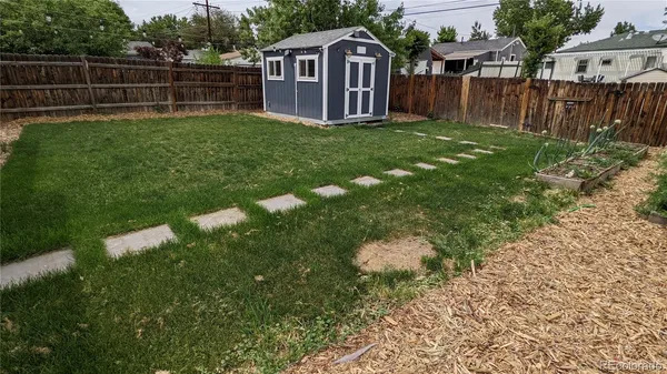 a view of backyard of house with wooden fence