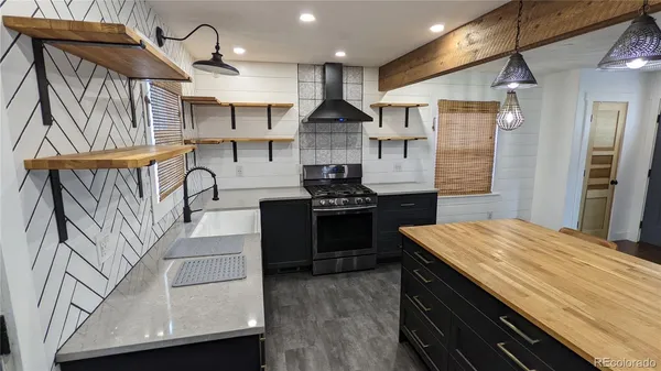 a kitchen with stainless steel appliances granite countertop a sink a stove and a refrigerator