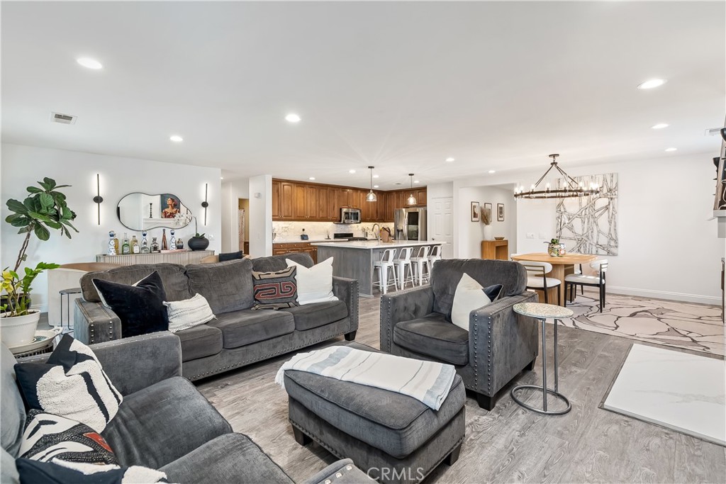 14428 Table Bluff Circle Eastvale, CA 92880 - Photo 18 of 29 a living room with furniture kitchen view and a chandelier