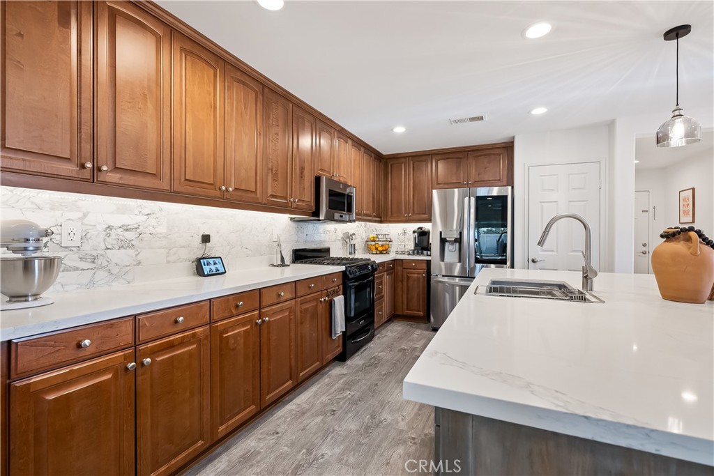 14428 Table Bluff Circle Eastvale, CA 92880 - Photo 20 of 29 a kitchen with sink a refrigerator and cabinets