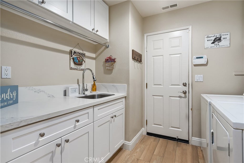 14428 Table Bluff Circle Eastvale, CA 92880 - Photo 21 of 29 a kitchen with a sink and wooden floor