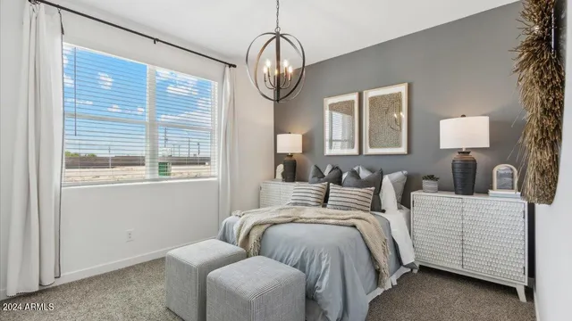 a bedroom with bed a chandelier and a window