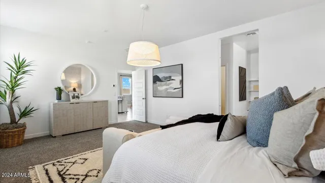 a bedroom with a bed and a potted plant