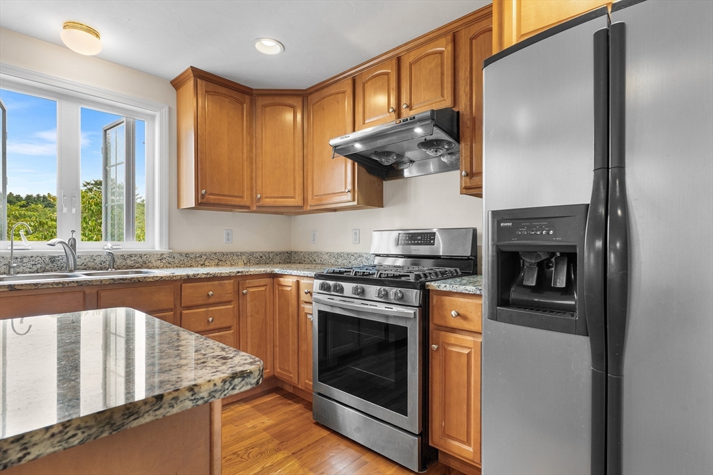 70 Loring Avenue Boxborough, MA 01719 - Photo 4 of 33 a kitchen with stainless steel appliances granite countertop a stove and a refrigerator