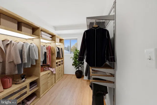 a view of walk in closet with clothes and shoes
