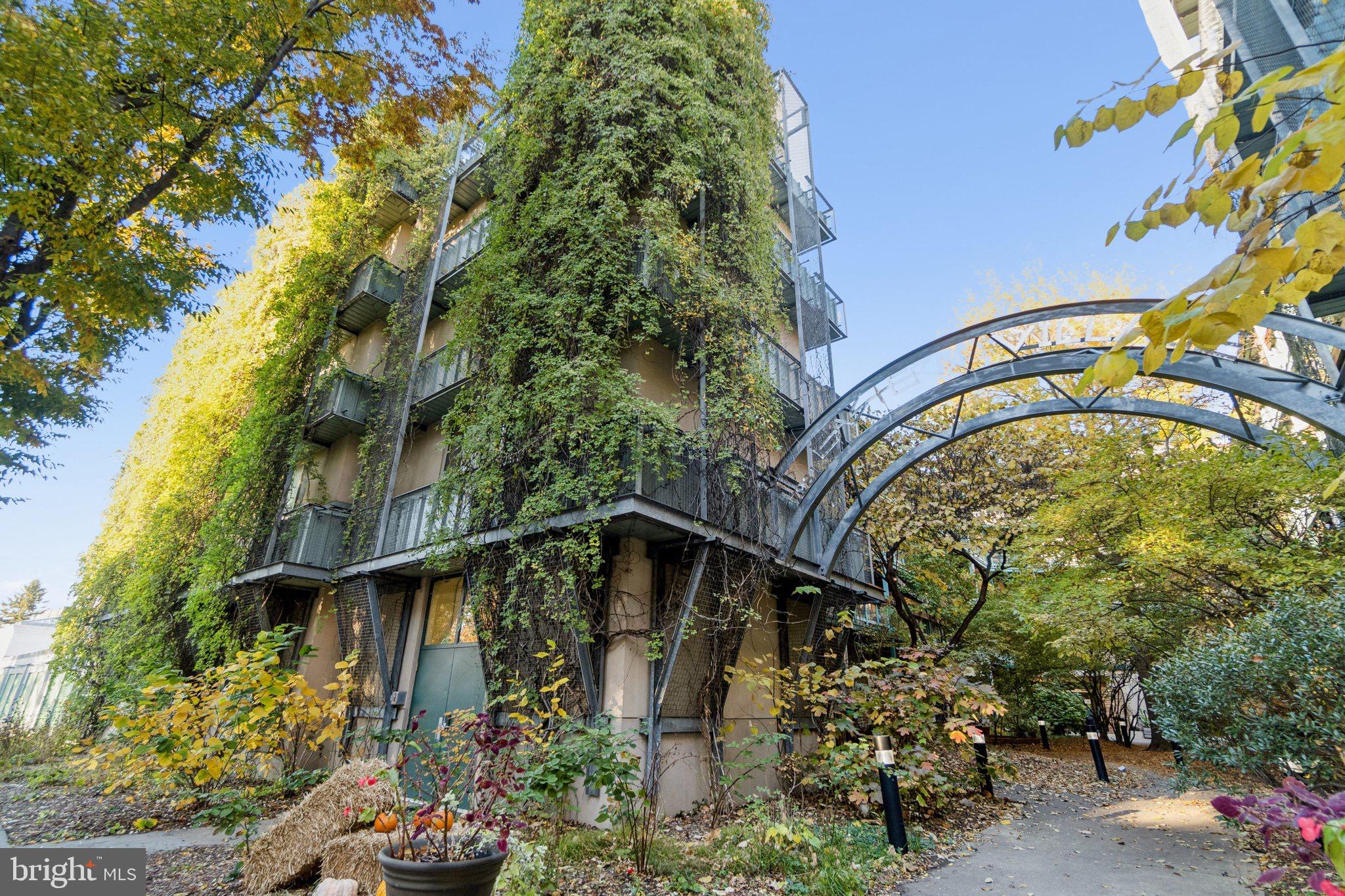 7981 Eastern Avenue Northwest, Unit 204 Silver Spring, MD 20910 - Photo 31 of 32 Lush greenery envelops a modern residence