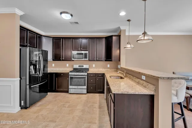 a kitchen with stainless steel appliances granite countertop a stove a sink and a refrigerator
