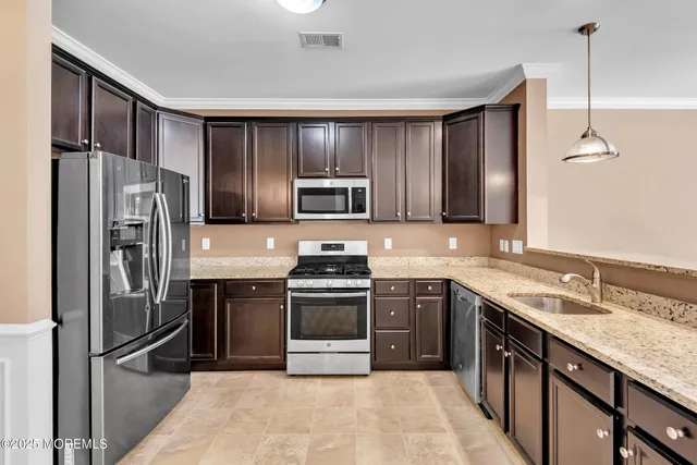 a kitchen with stainless steel appliances granite countertop a stove a sink and a microwave