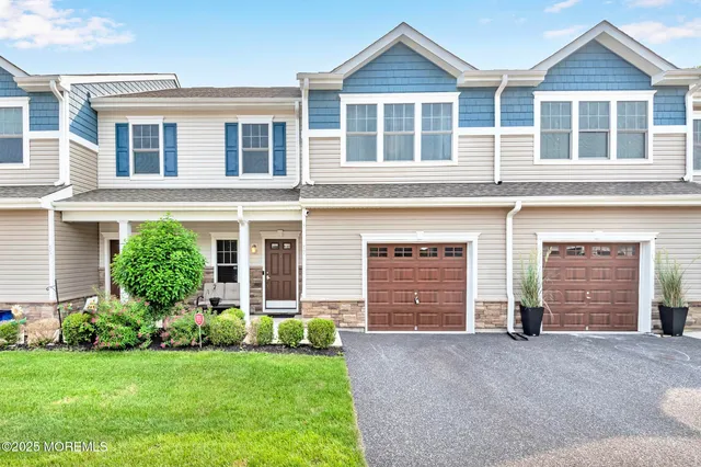 front view of a house with a yard and garage