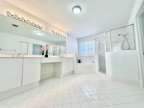 a bathroom with a tub a sink and mirror