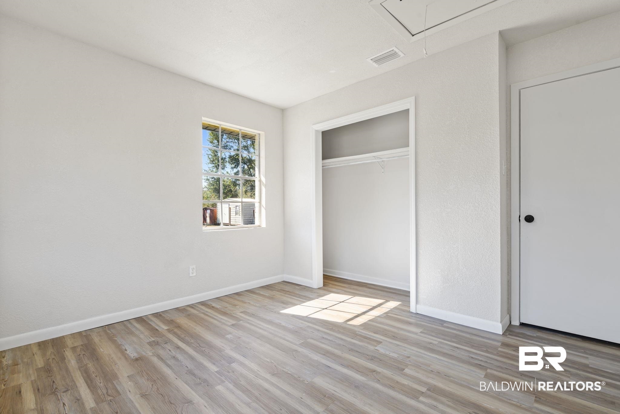 910 Moran Street Bay Minette, AL 36507 - Photo 11 of 20 Unfurnished bedroom with light wood-style floors and a closet