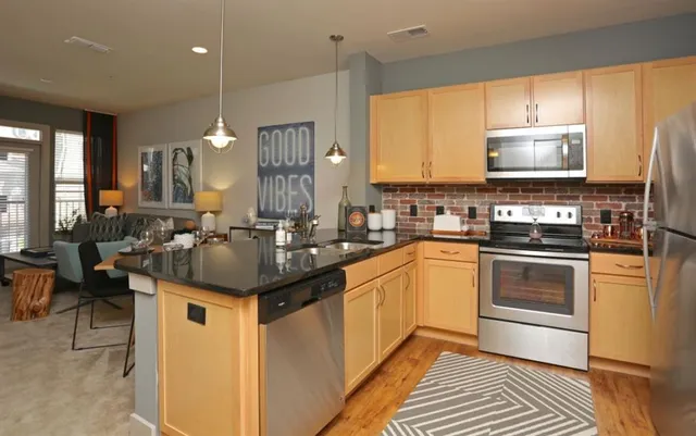 a kitchen with stainless steel appliances granite countertop a sink a stove and a refrigerator
