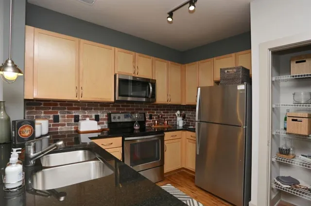 a kitchen with a refrigerator a stove top oven a sink and cabinets