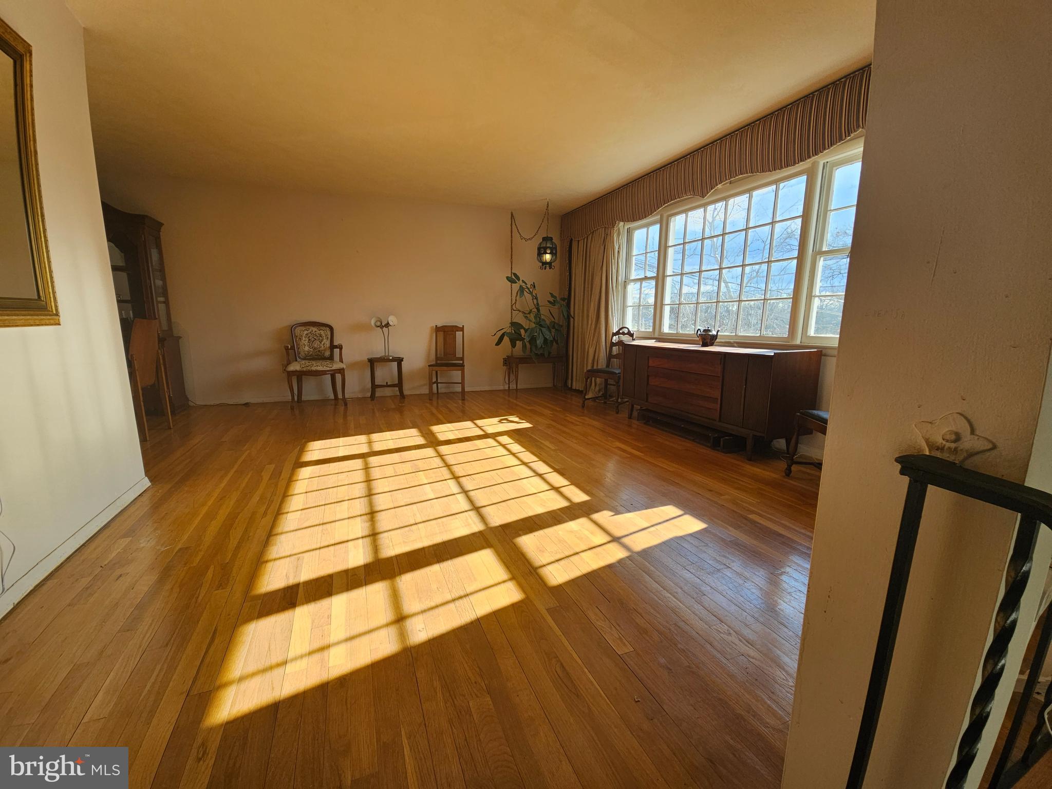 4523 Kinmount Road Lanham, MD 20706 - Photo 10 of 38 a living room with a rug floor to ceiling windows and a wooden floor