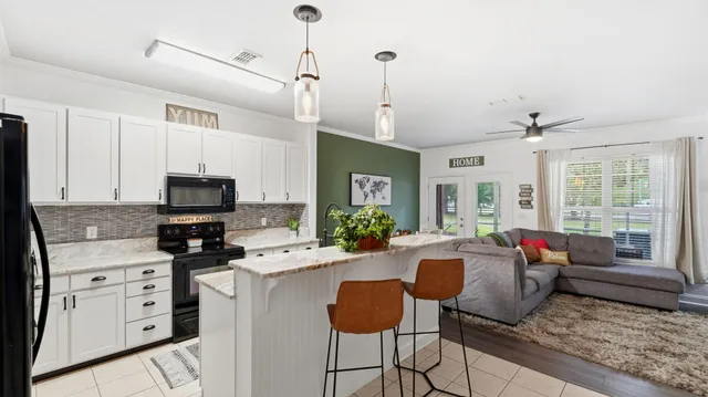 a kitchen with stainless steel appliances a stove a sink a microwave a refrigerator and cabinets